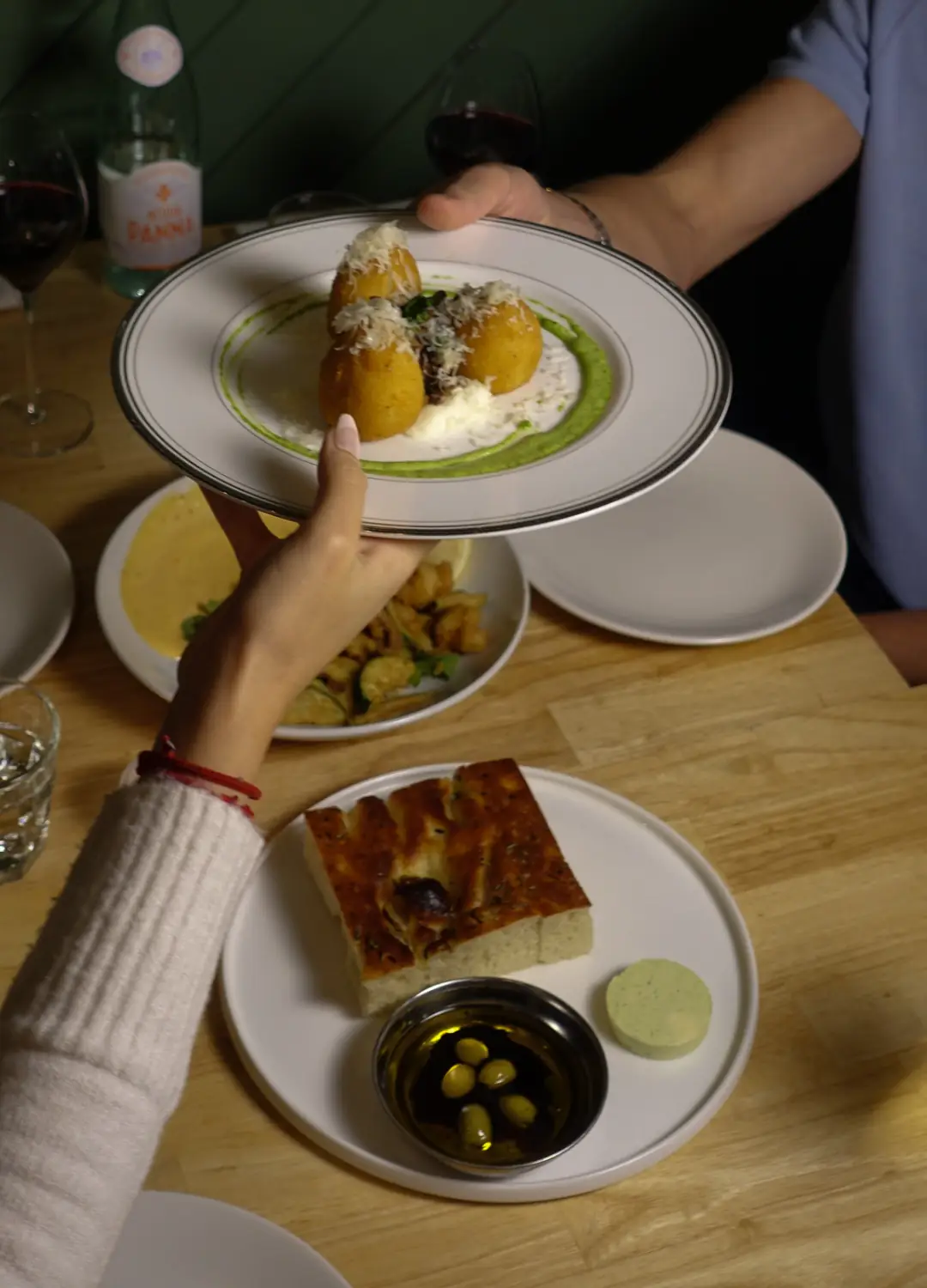 Arancini et focaccia sur la table, mur vert en arrière-plan
