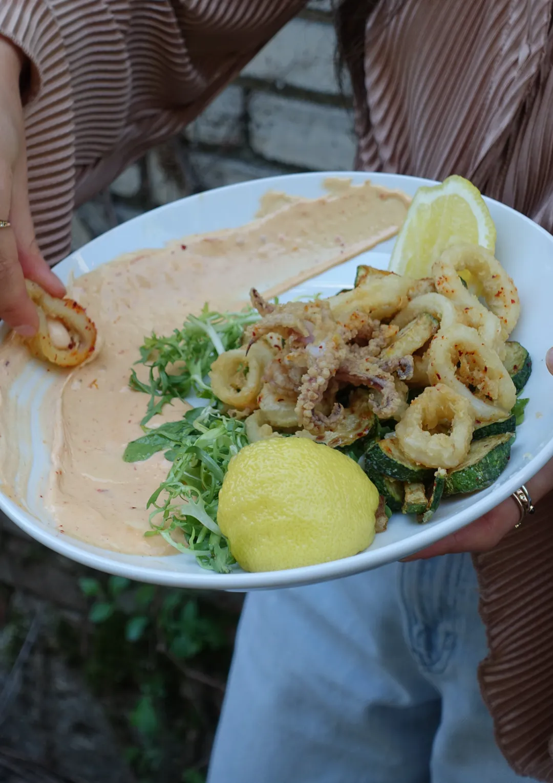 Calmars frits et courgettes grillées avec trempette, servis dans une grande assiette blanche