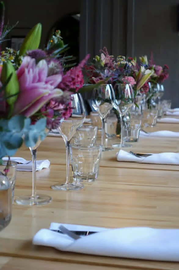 Longue table dressée avec des bouquets de fleurs