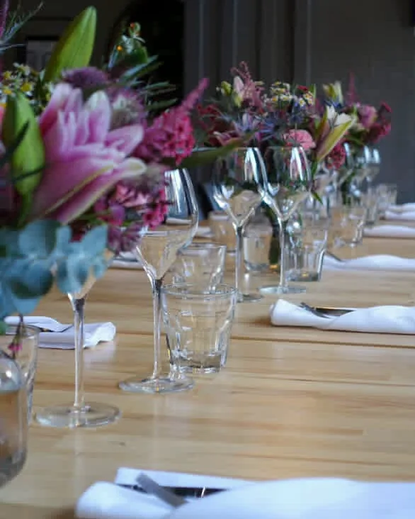 Longue table dressée avec des bouquets de fleurs